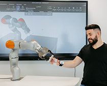 Ein Mensch reicht einem Roboter die Hand